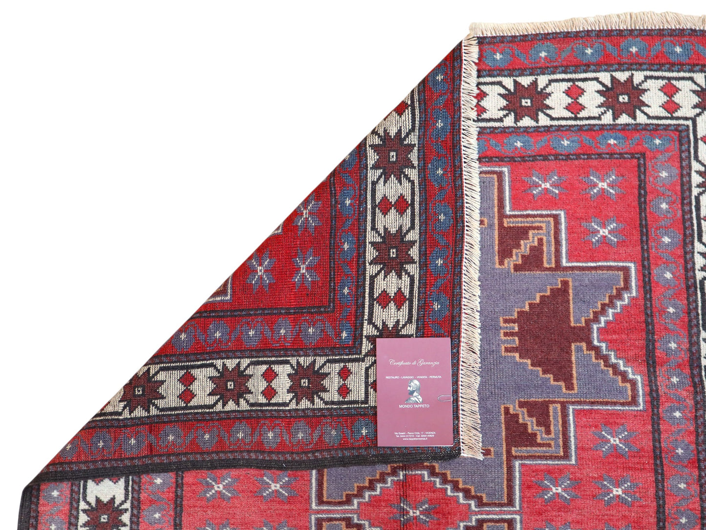 Tappeto Kazak 181x113 cm con motivo geometrico a stelle in rosso, blu e beige, annodato a mano con lana pregiata e ordito in cotone robusto.