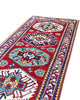 Passatoia Kazak afgana 351x91 cm annodata a mano in lana, con un design audace caratterizzato da motivi geometrici su un fondo rosso intenso.