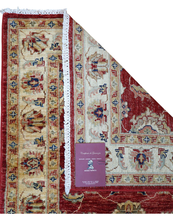 Passatoia Ziegler afgana 301x88 cm annodata a mano in lana, con motivi contemporanei su fondo rosso melograno e un'elegante cornice beige.