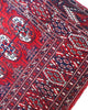 Tappeto Bukhara 324x205 cm con fondo rosso scuro e motivi a gul geometrici in nero, avorio e blu, tramato ed annodato a mano, provenienza Bukhara.