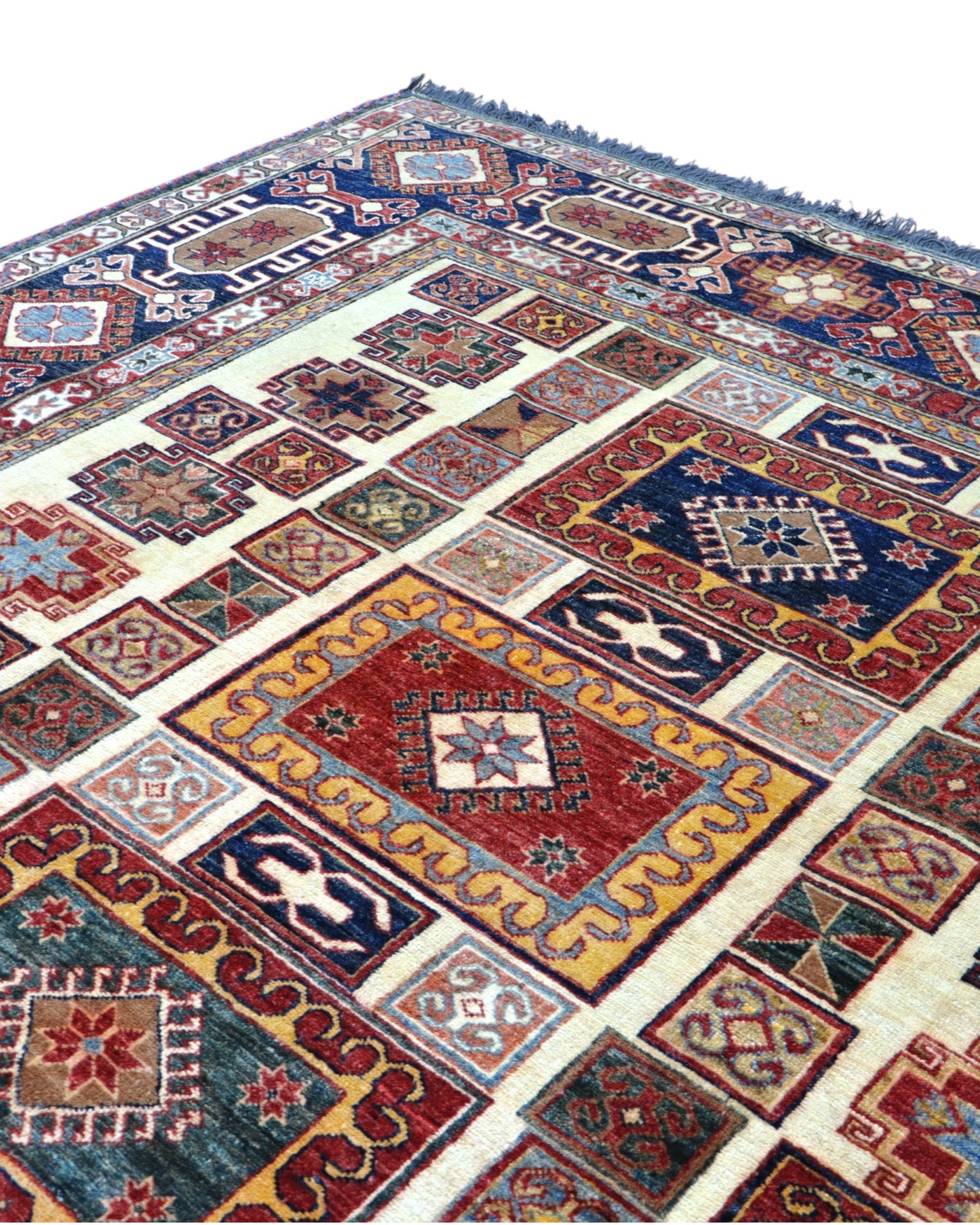 Tappeto Kazak 285x222 cm con fondo chiaro, motivi geometrici multicolore e bordure ricche, tramato ed annodato a mano, provenienza Caucaso.