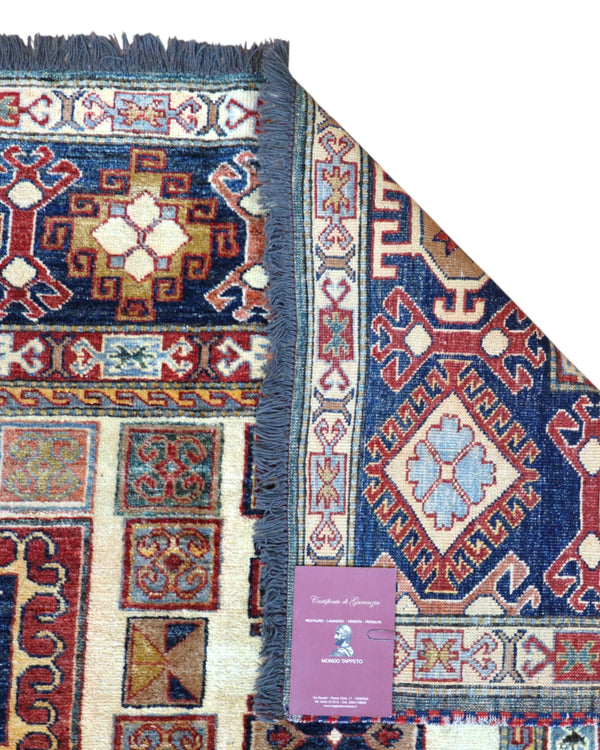 Tappeto Kazak 285x222 cm con fondo chiaro, motivi geometrici multicolore e bordure ricche, tramato ed annodato a mano, provenienza Caucaso.