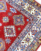 Tappeto Shirvan 300x208 cm con fondo rosso, motivi geometrici blu, gialli e avorio, tramato ed annodato a mano, provenienza Caucaso.