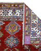Tappeto Shirvan 300x208 cm con fondo rosso, motivi geometrici blu, gialli e avorio, tramato ed annodato a mano, provenienza Caucaso.