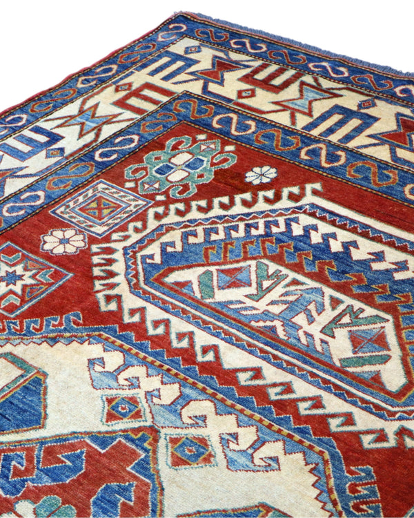 Tappeto Kazak 246x210 cm con fondo avorio e rosso, medaglione geometrico blu e motivi stilizzati, tramato ed annodato a mano, provenienza Caucaso.
