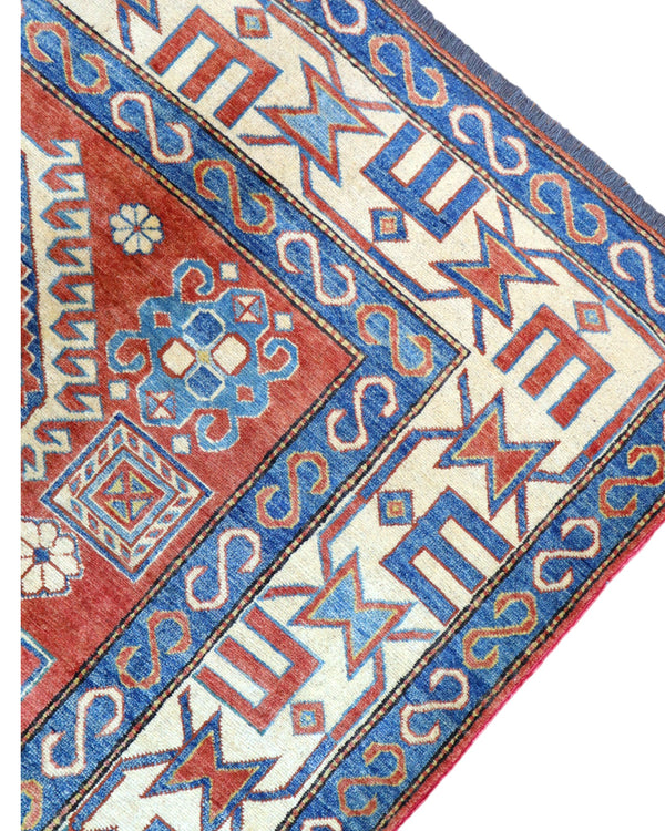 Tappeto Kazak 246x210 cm con fondo avorio e rosso, medaglione geometrico blu e motivi stilizzati, tramato ed annodato a mano, provenienza Caucaso.