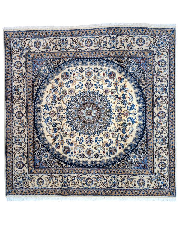 Tappeto Nain con medaglione floreale stilizzato su fondo beige e dettagli celesti, annodato a mano in Persia con lana mista seta e cotone.