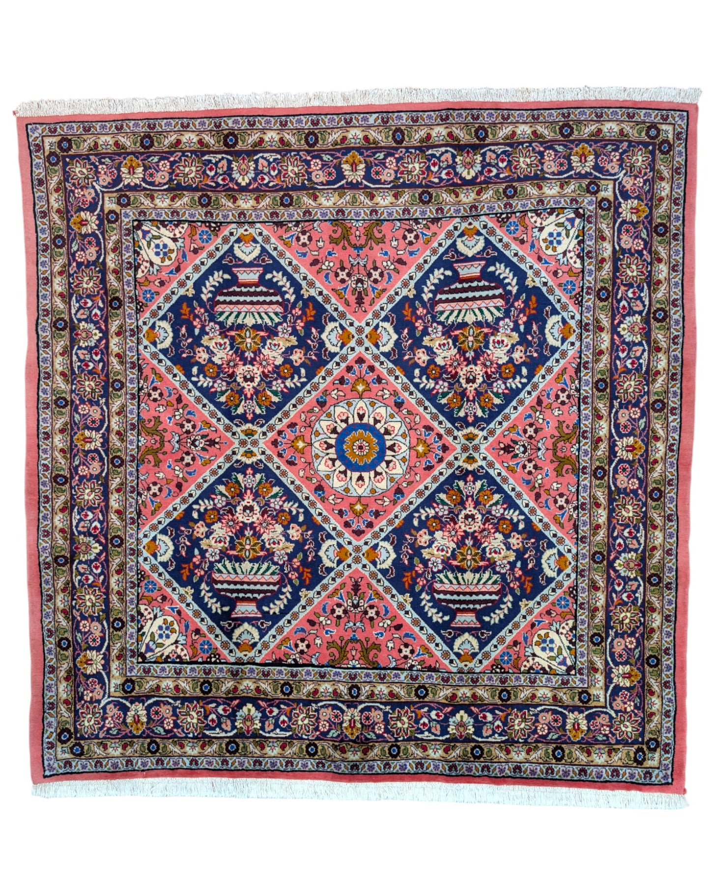 Tappeto Lilian con campo rosso mattone e motivi floreali stilizzati blu, annodato a mano in Persia con cotone e lana vegetale.