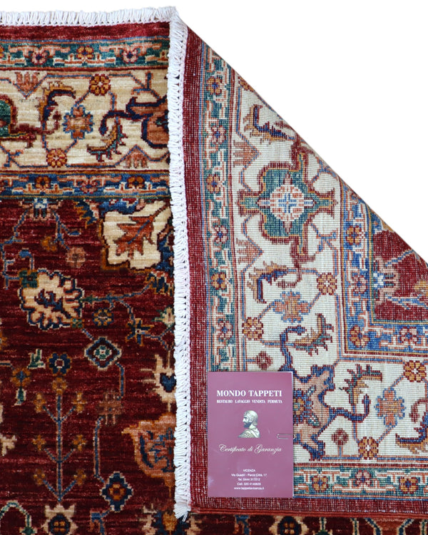 Tappeto Farahan 176x127 cm con motivi floreali e geometrici in rosso, blu, verde e oro su fondo beige.