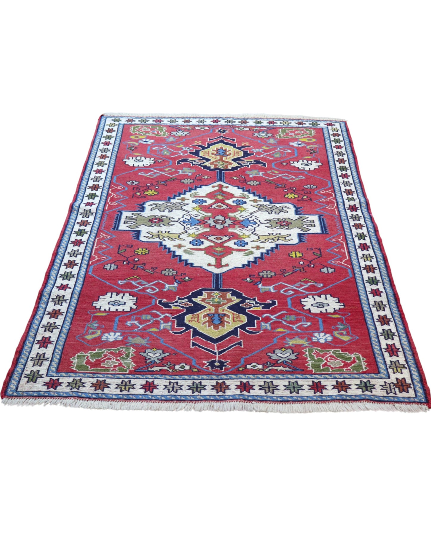 Tappeto Kilim 190x122 cm con motivi geometrici in rosso, blu, giallo e verde su fondo beige.