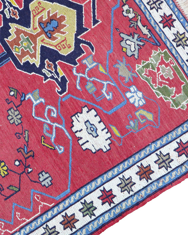 Tappeto Kilim 190x122 cm con motivi geometrici in rosso, blu, giallo e verde su fondo beige.