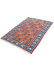 Tappeto Kilim 181x130 cm con motivi geometrici e figure stilizzate in blu, verde e rosso su fondo arancione e bordura decorata.