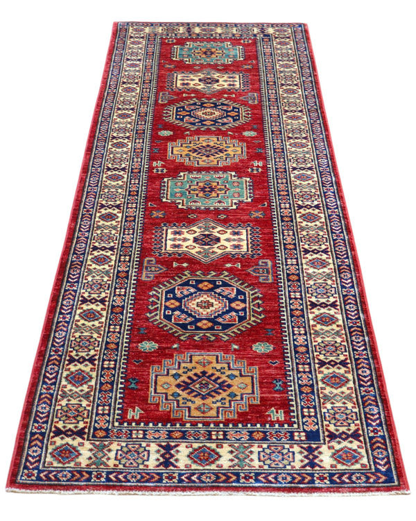 Tappeto Kazak 236x82 cm, corridore afghano annodato a mano in lana, fondo rosso con motivi geometrici blu e verdi.