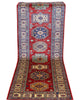 Tappeto Kazak 236x82 cm, corridore afghano annodato a mano in lana, fondo rosso con motivi geometrici blu e verdi.