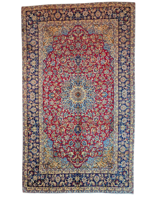 Tappeto persiano Najafabad 500x400 cm, fondo rosso con ampio medaglione centrale blu e cornice floreale scura, annodato a mano in lana vegetale.