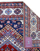 Tappeto Shirvan 274x184 cm con fondo rosso, medaglione centrale blu e avorio e bordure geometriche multicolori, tramato ed annodato a mano.