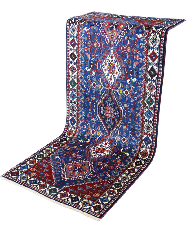 Tappeto persiano Yalameh 204x82 cm, corridore con fondo blu intenso e motivi geometrici rossi, avorio e verdi, annodato a mano in lana vegetale.