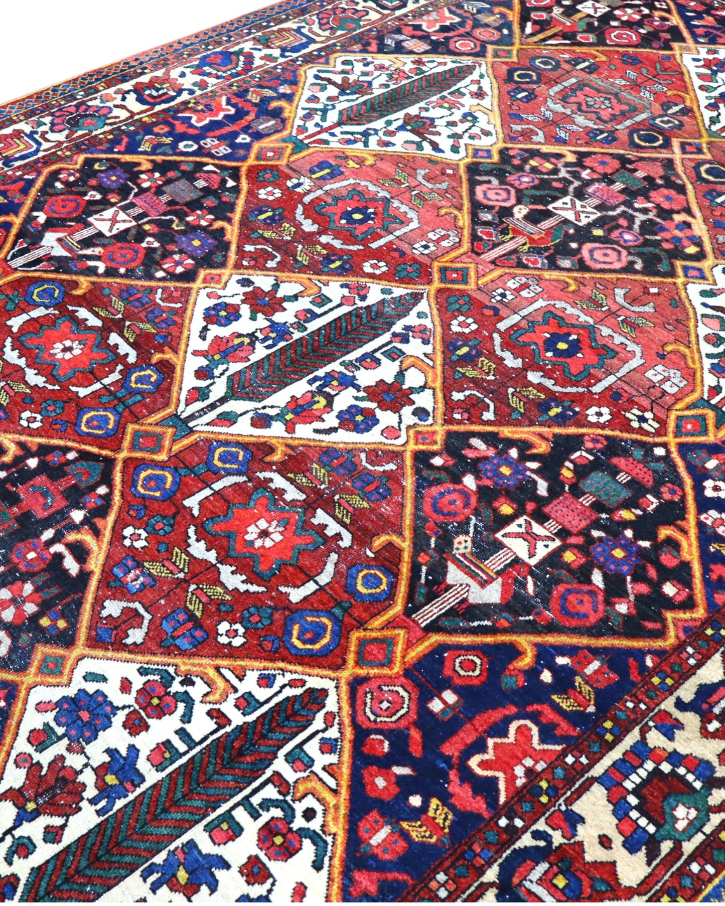 Tappeto Bakhtiari persiano 341x246 cm, annodato a mano in lana e cotone, fondo rosso con motivi geometrici e floreali.