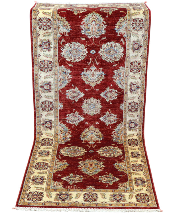 Tappeto Ziegler Afghan 199x83 cm annodato a mano, fondo rosso intenso con decorazioni floreali avorio e cornice chiara.