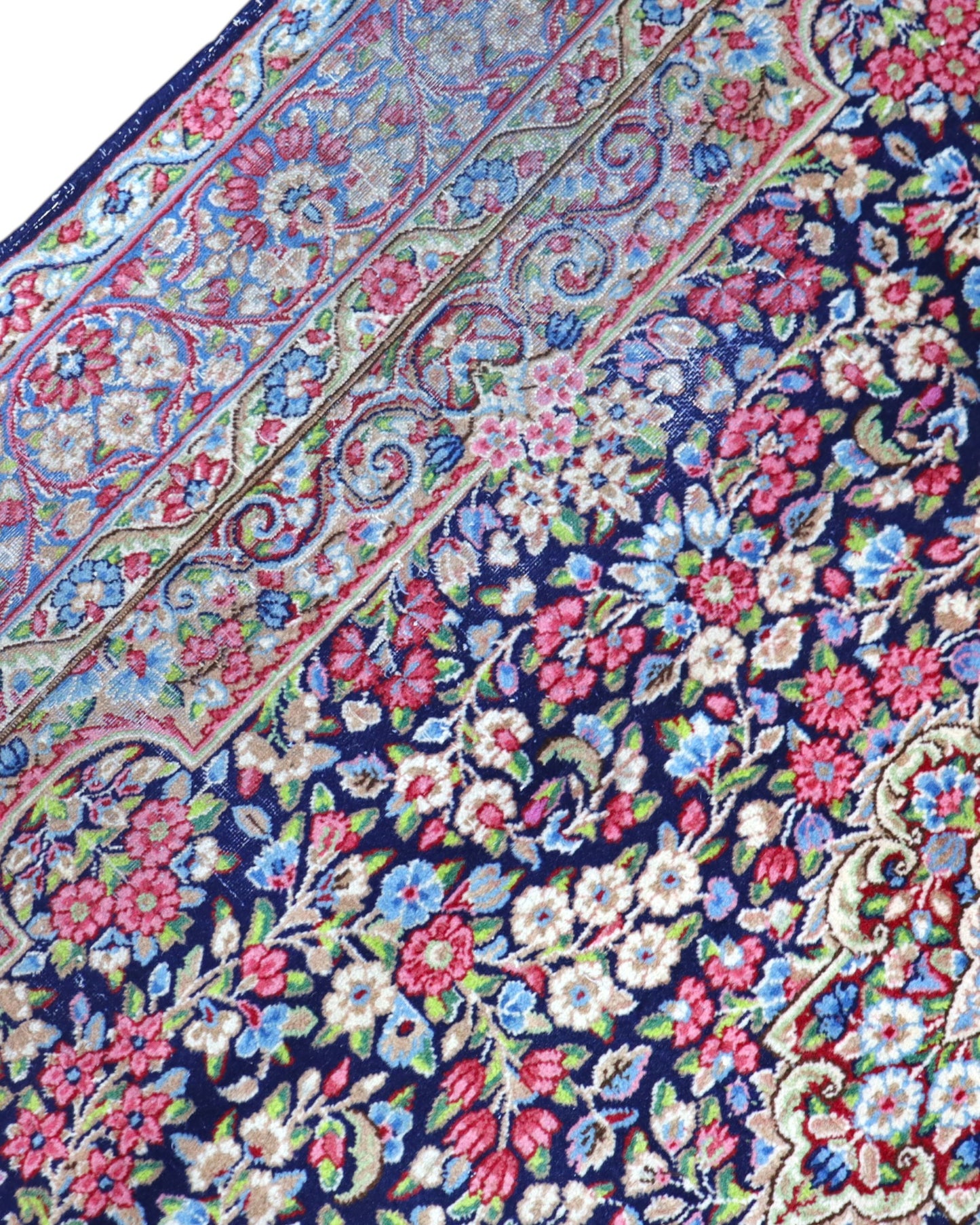 Tappeto Kerman 296x197 cm con fondo blu notte e motivi floreali rosa, avorio e verde, tramato ed annodato a mano, provenienza Kerman.