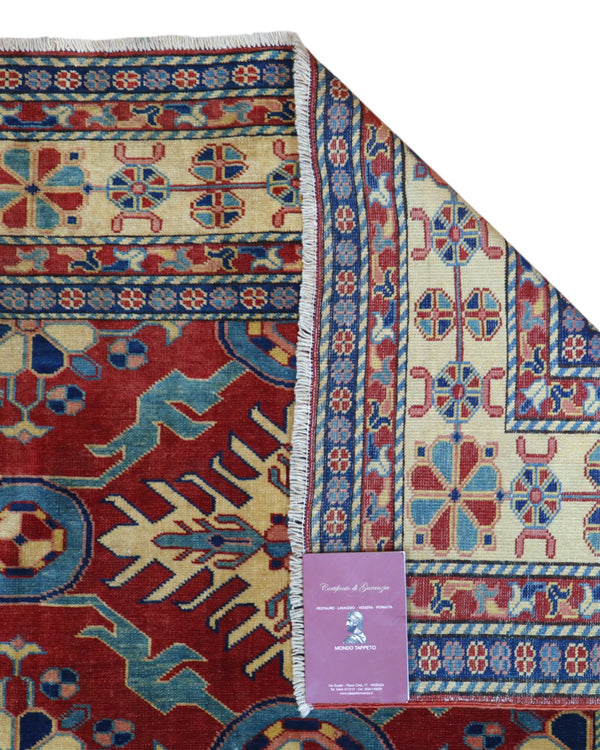 Tappeto Shirvan 289x196 cm con fondo rosso e motivi geometrici gialli, blu e avorio, tramato ed annodato a mano, provenienza Caucaso.