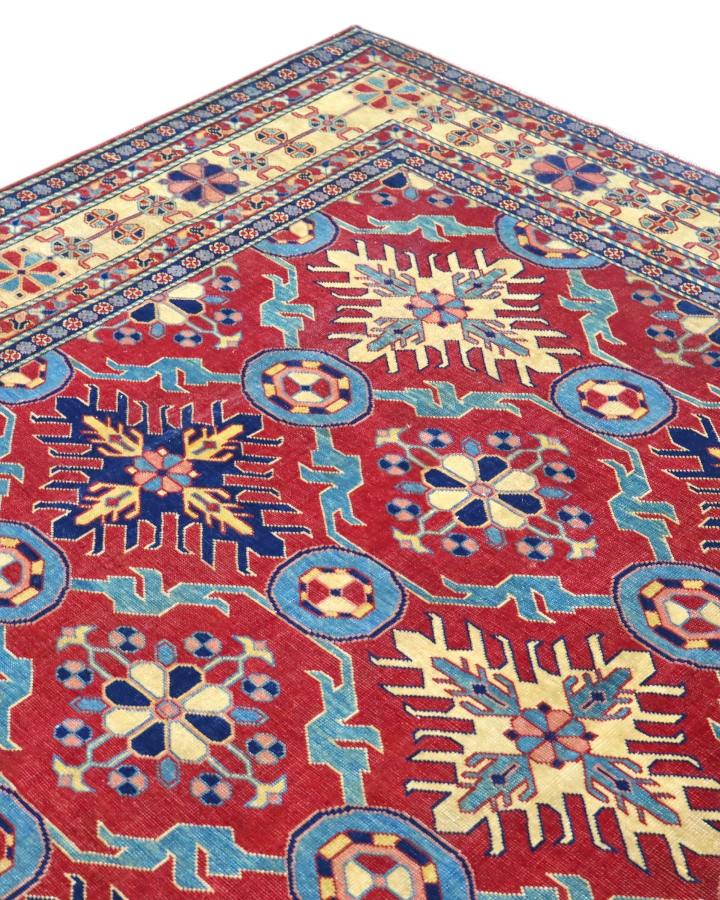 Tappeto Shirvan 289x196 cm con fondo rosso e motivi geometrici gialli, blu e avorio, tramato ed annodato a mano, provenienza Caucaso.