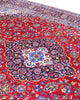 Tappeto persiano Kashan 402x297 cm, fondo rosso con medaglione centrale blu e avorio, annodato a mano in lana vegetale.