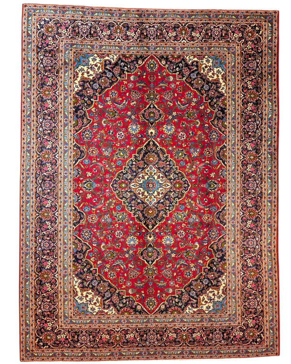 Tappeto persiano Kashan 402x297 cm, fondo rosso con medaglione centrale blu e avorio, annodato a mano in lana vegetale.