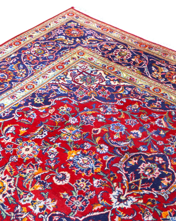 Tappeto persiano Kashan 238x247cm con fondo rosso, medaglione avorio e ricchi motivi floreali blu e oro.