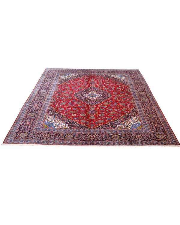 Tappeto persiano Kashan 402x297 cm, fondo rosso con medaglione centrale blu e avorio, annodato a mano in lana vegetale.