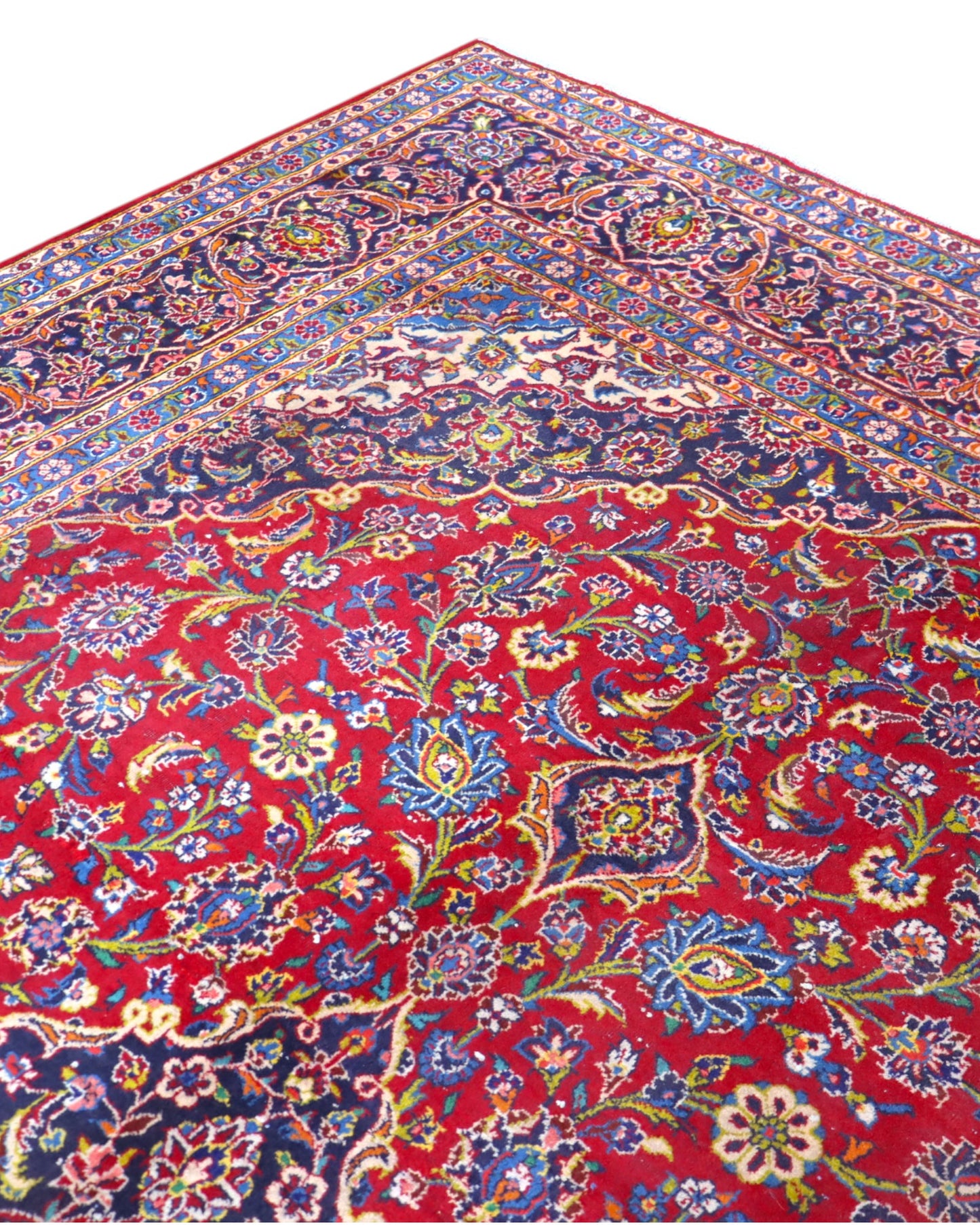 Tappeto persiano Kashan 400x290 cm, fondo rosso con medaglione centrale blu e avorio, cornice scura floreale, annodato a mano in lana vegetale.