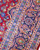 Tappeto persiano Kashan 400x290 cm, fondo rosso con medaglione centrale blu e avorio, cornice scura floreale, annodato a mano in lana vegetale.