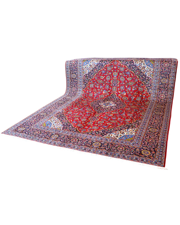 Tappeto persiano Kashan 402x297 cm, fondo rosso con medaglione centrale blu e avorio, annodato a mano in lana vegetale.