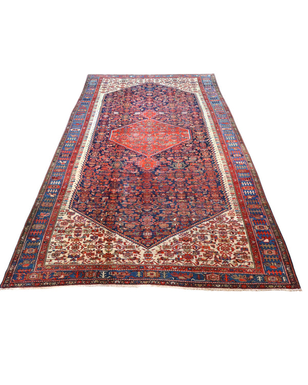 Tappeto persiano Malayer 390x297 cm, fondo blu con medaglione geometrico rosso, estremità avorio e cornice floreale, annodato a mano in lana vegetale.