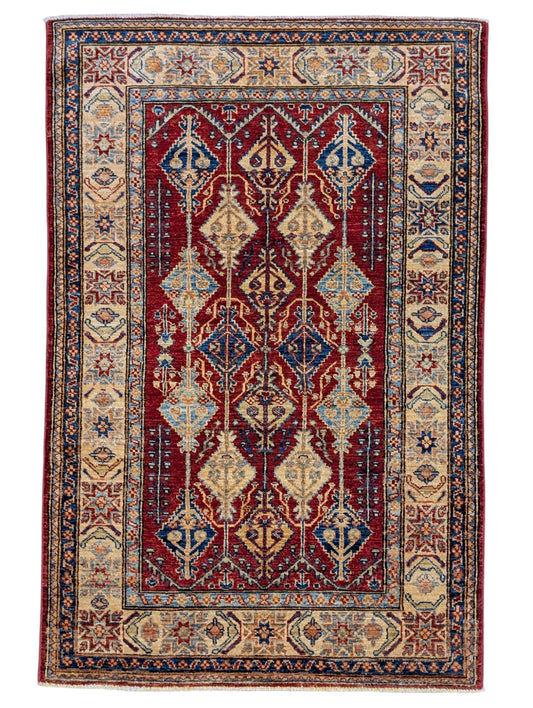 Tappeto Shirvan 154x102 cm, annodato a mano in Persia, fondo rosso con motivi geometrici blu, giallo e beige, lana pregiata e cotone resistente, certificato di autenticità incluso.