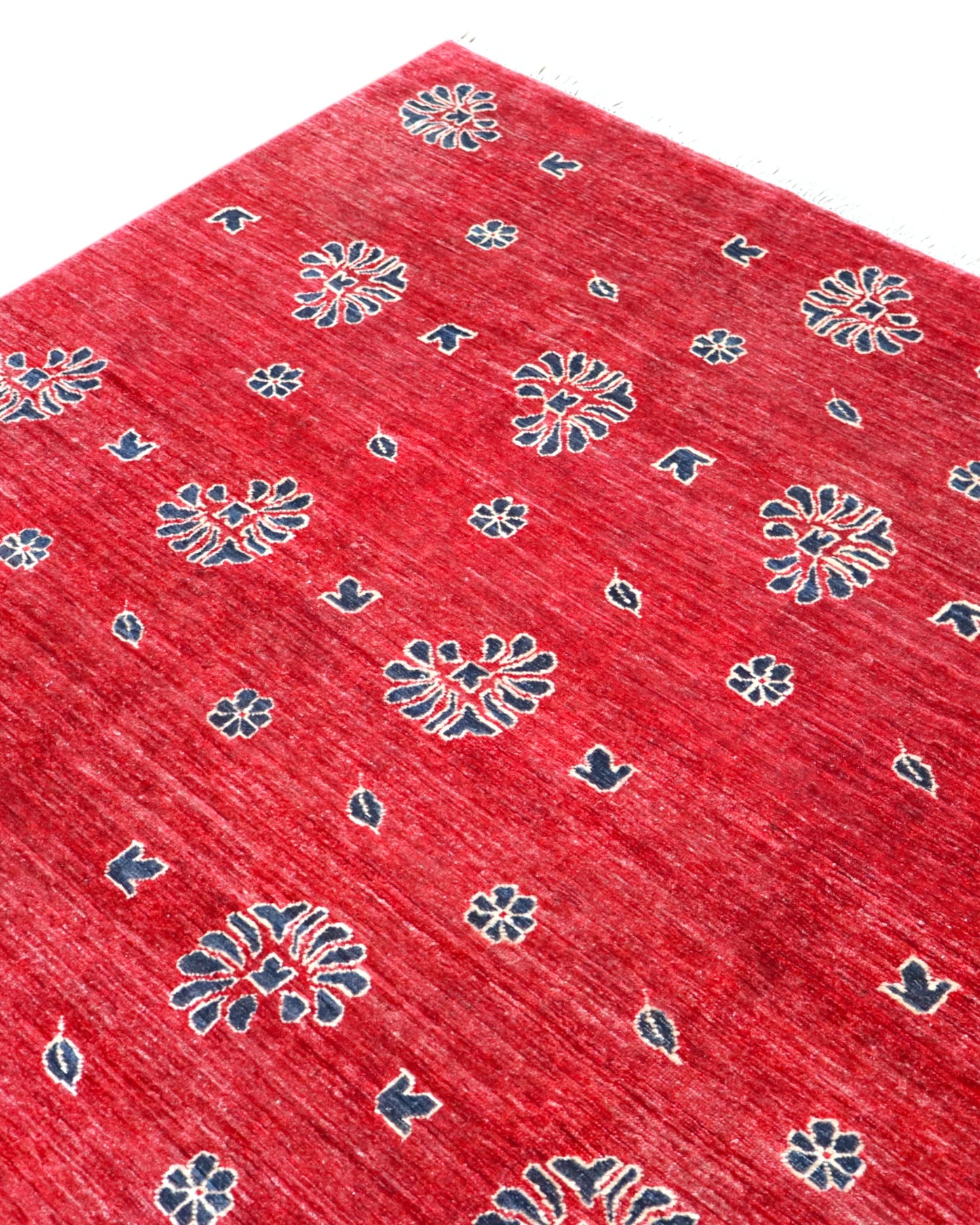 Tappeto Moderno 349x248 cm annodato a mano, rettangolare, fondo rosso con motivi decorativi stilizzati, realizzato in cotone e lana con colori vegetali.