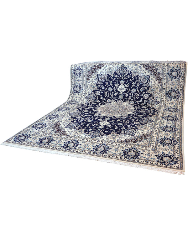 Tappeto persiano Nain 390x297 cm, fondo blu notte con medaglione centrale e motivi floreali avorio e azzurro, annodato a mano in lana vegetale.