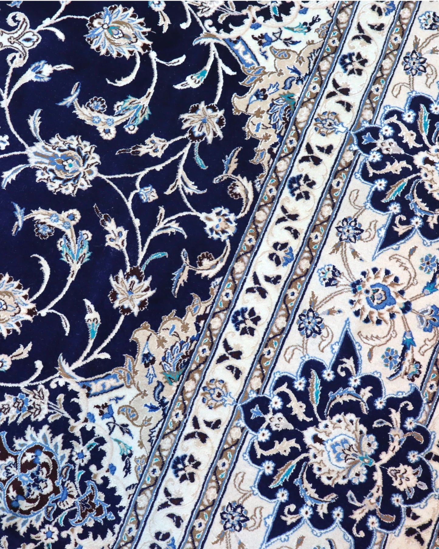 Tappeto persiano Nain 390x297 cm, fondo blu notte con medaglione centrale e motivi floreali avorio e azzurro, annodato a mano in lana vegetale.