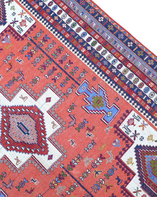 Tappeto Kilim 180x125 cm persiano tessuto a mano, con motivi geometrici tribali e medaglione centrale su fondo rosso mattone.