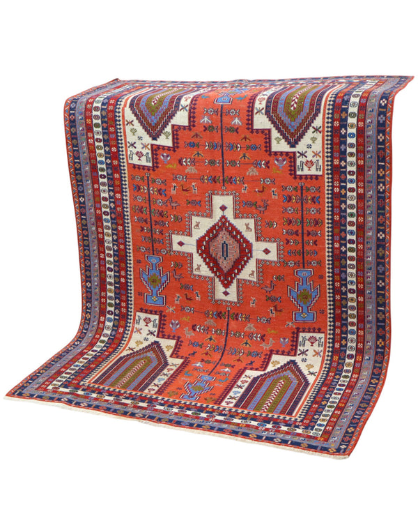 Tappeto Kilim 180x125 cm persiano tessuto a mano, con motivi geometrici tribali e medaglione centrale su fondo rosso mattone.