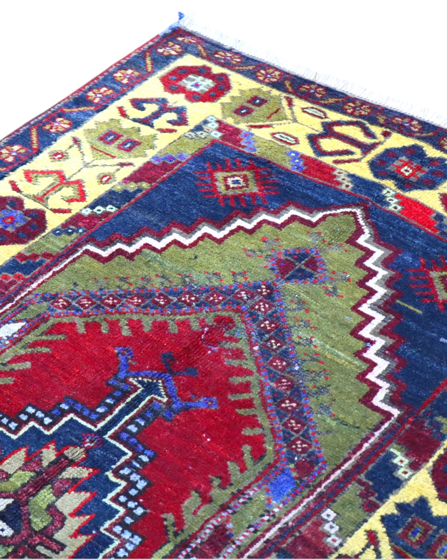 Tappeto Turco 179x103 cm, annodato a mano, con medaglione centrale geometrico rosso, motivi tribali e bordura gialla decorata.