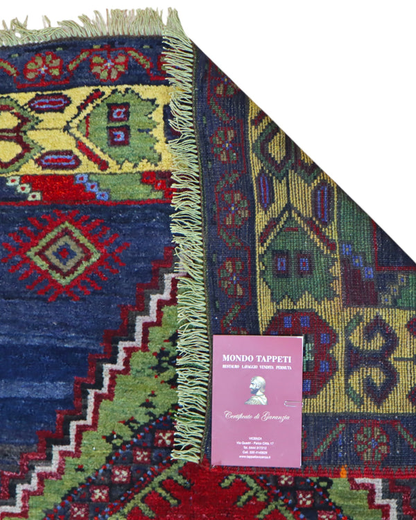 Tappeto Turco 179x103 cm, annodato a mano, con medaglione centrale geometrico rosso, motivi tribali e bordura gialla decorata.