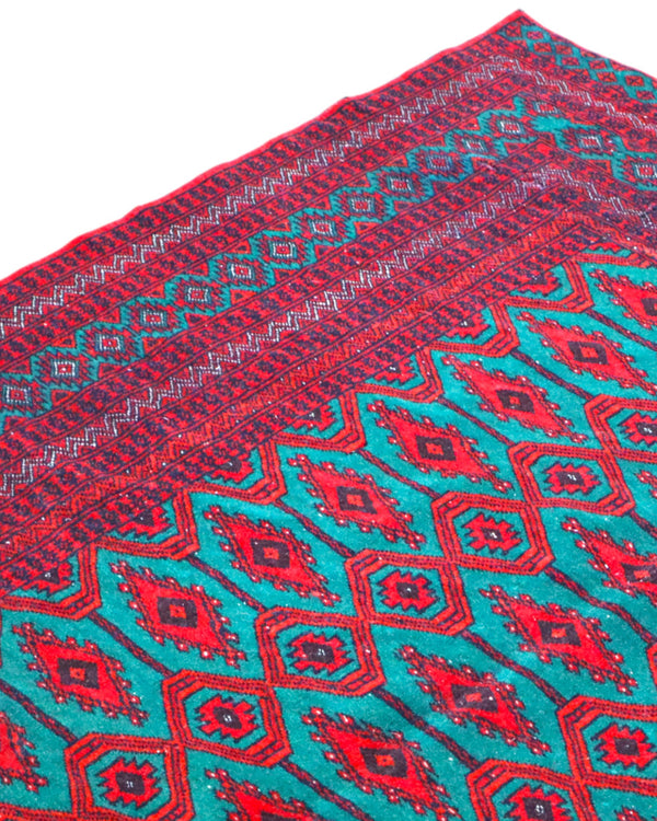 Tappeto Bukhara 172x126 cm annodato a mano, con motivi geometrici gul su fondo verde smeraldo e cornice rossa.