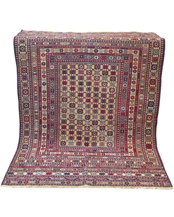 Tappeto Sumakh 180x130 cm con motivi geometrici e floreali in rosso, blu e crema su fondo beige.