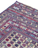 Tappeto Sumakh 180x130 cm con motivi geometrici e floreali in rosso, blu e crema su fondo beige.