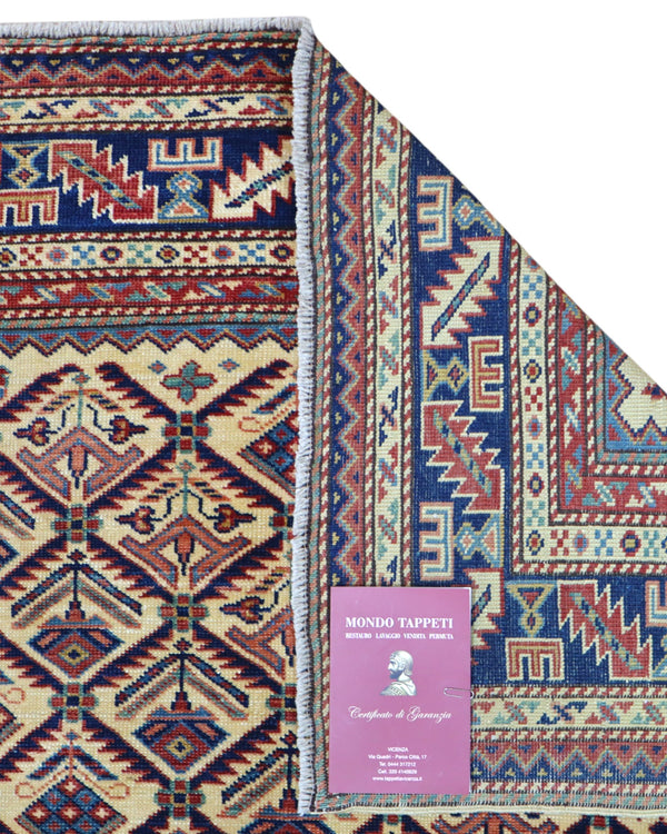 Tappeto Shirvan 166x120 cm in lana annodata a mano, fondo chiaro con rombi geometrici e cornici caucasiche.