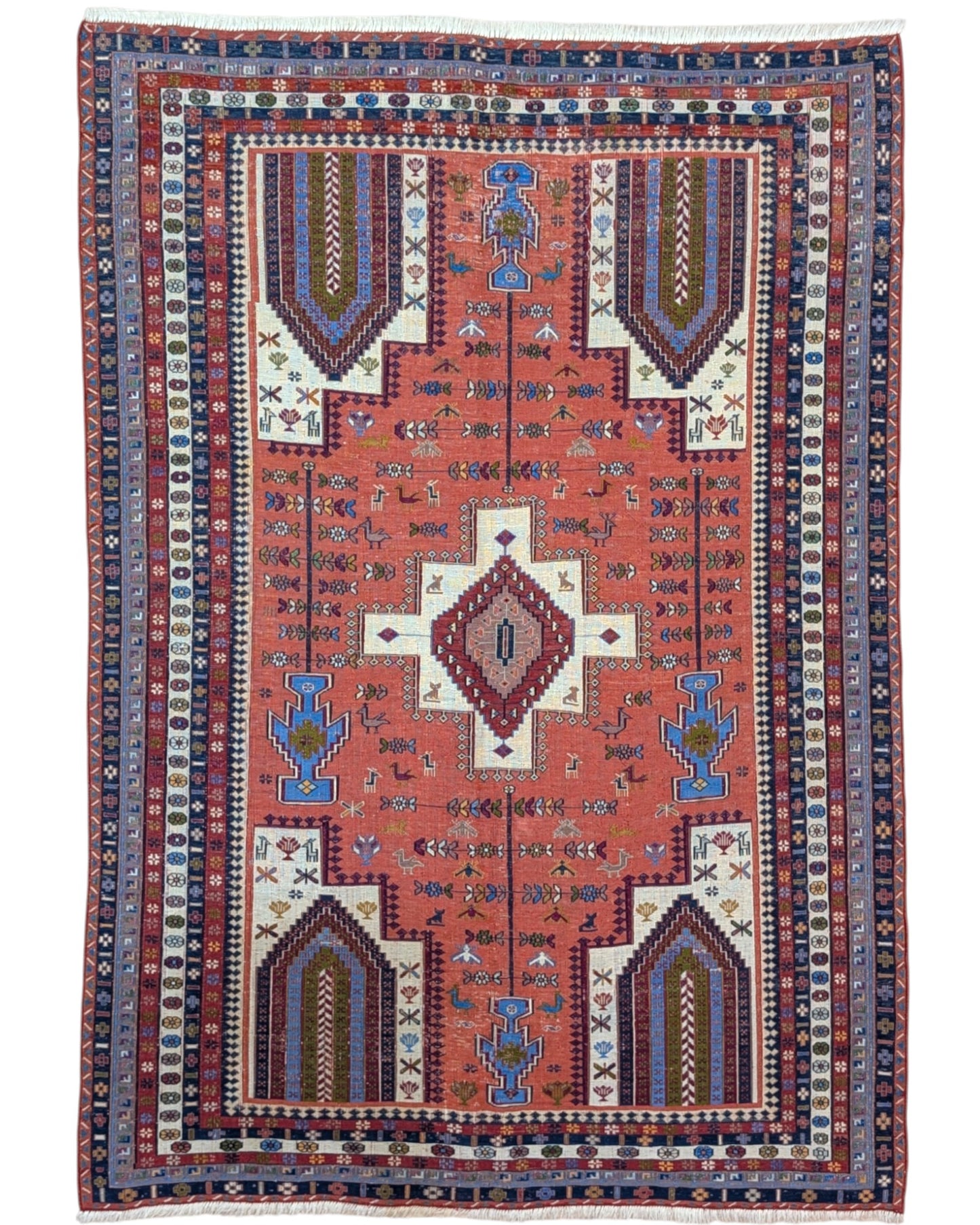 Tappeto Kilim 180x125 cm persiano tessuto a mano, con motivi geometrici tribali e medaglione centrale su fondo rosso mattone.