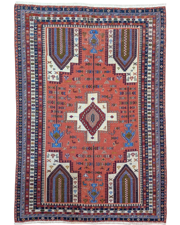 Tappeto Kilim 180x125 cm persiano tessuto a mano, con motivi geometrici tribali e medaglione centrale su fondo rosso mattone.