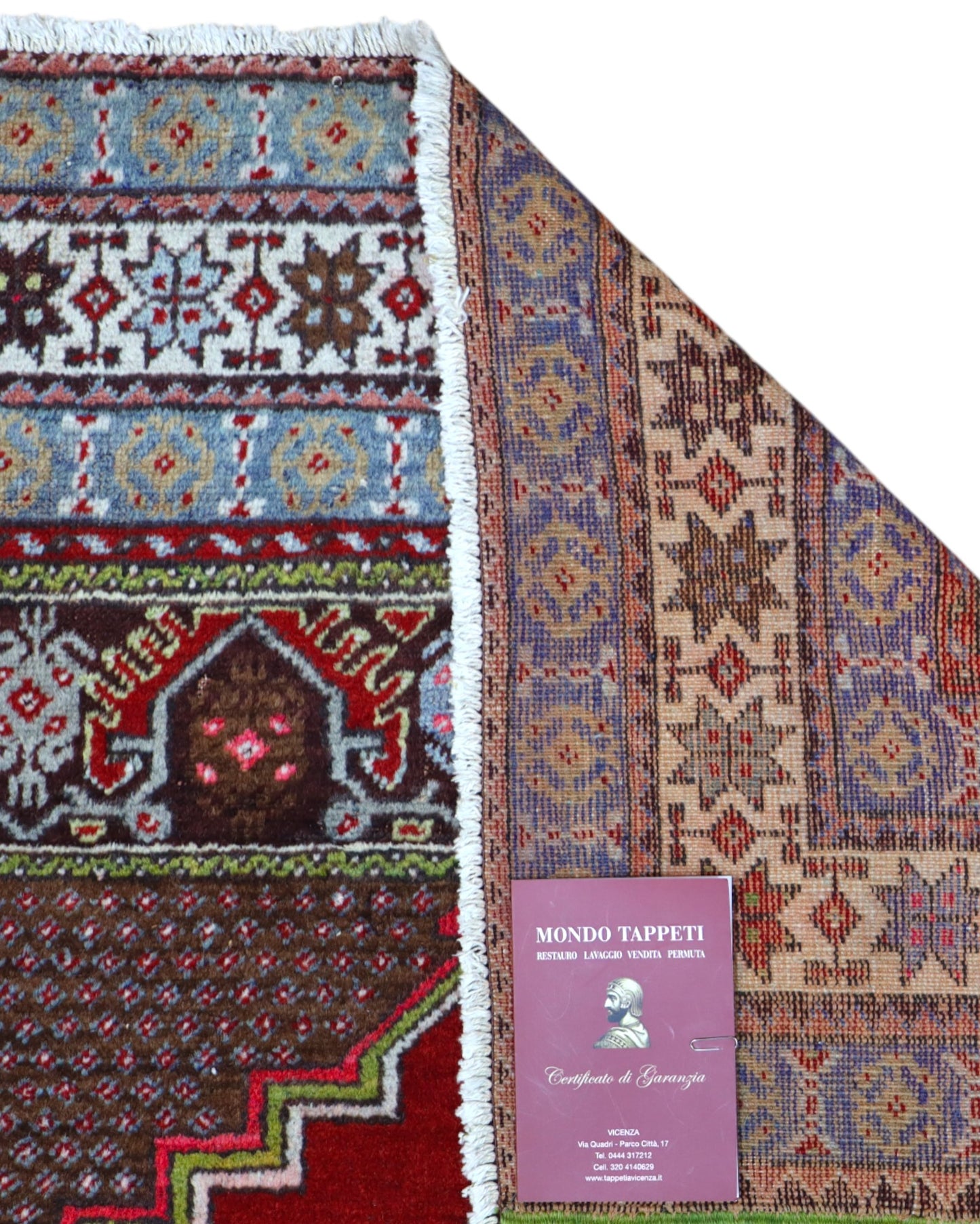 Tappeto Turco 170x108 cm annodato a mano, con campo rosso, medaglione bianco centrale e bordo riccamente decorato.