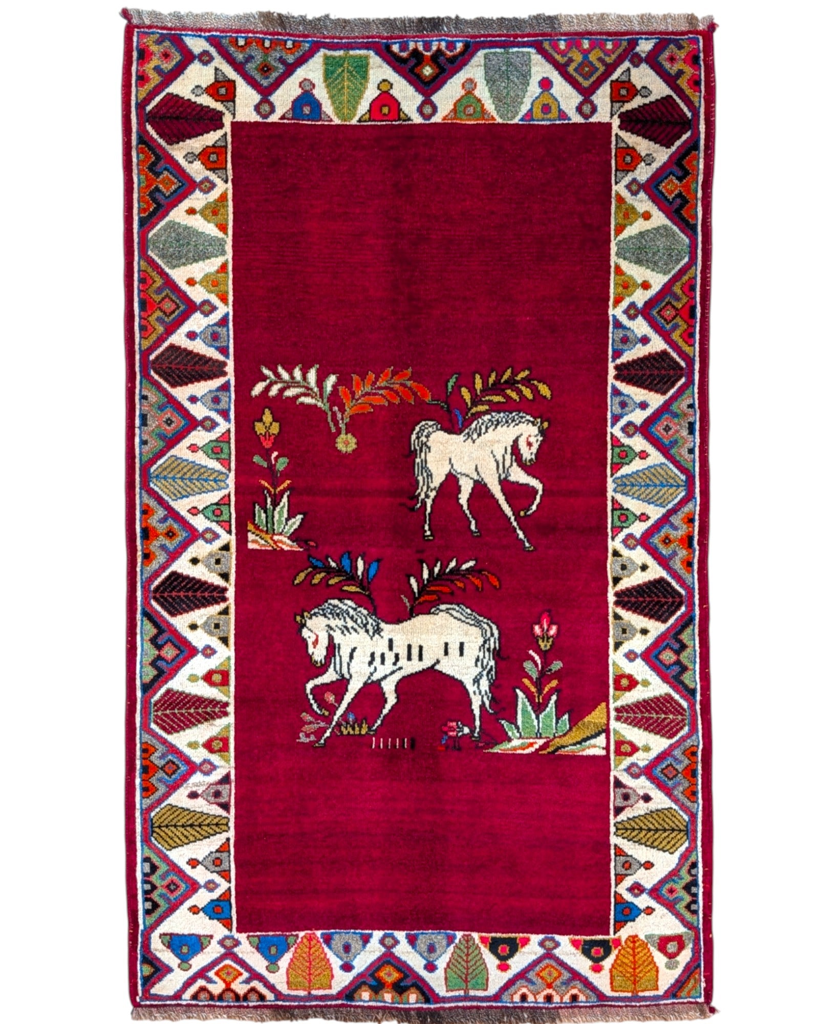 Tappeto Gashgai 185x111 cm annodato a mano, con cavalli stilizzati bianchi su fondo rosso e cornice geometrica multicolore.